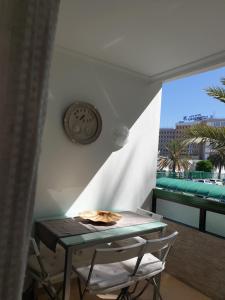 una mesa y sillas en una habitación con balcón en Tara apartment, en Playa del Inglés