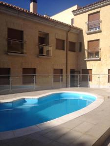 a swimming pool in front of a building at Apartamento turisticos Puente Romano P3 2-B in Salamanca