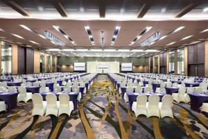 a large room with rows of chairs and a stage at Harper Palembang by ASTON in Palembang