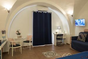 Sala de estar con cortina azul y mesa en Little House Napoli, en Nápoles