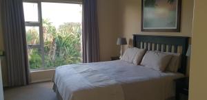 a bedroom with a bed and a large window at Ramsgate Palms Unit 20 in Ramsgate