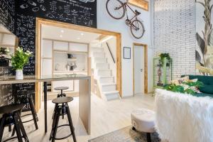a kitchen and living room with a bar and a bike on the wall at Own Budapest at Gozsdu in Budapest
