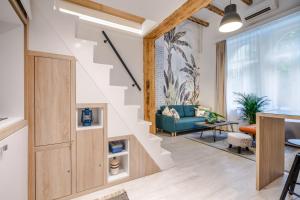 a living room with a staircase with a blue couch at Own Budapest at Gozsdu in Budapest