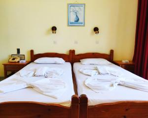 dos camas sentadas una al lado de la otra en un dormitorio en Titania Hotel Karpathos, en Karpathos