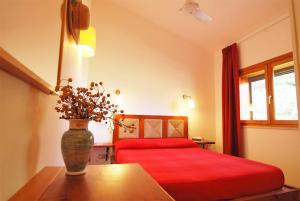 een slaapkamer met een bed en een vaas met bloemen op een tafel bij VILLA PRATO in Sperlonga