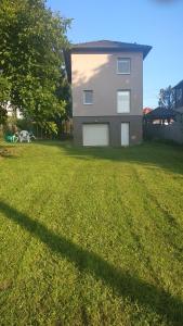 a house with a large lawn in front of it at Family Holiday Apartman in Nyíregyháza