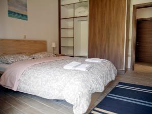 a bedroom with a bed with two towels on it at Moraitika Old Village Apartments in Moraitika