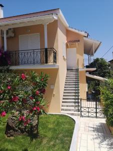 a house with stairs and flowers in front of it at Moraitika Old Village Apartments in Moraitika