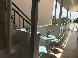 un balcón con una mesa con una maceta. en Spile Rooms Lukas, en Himare