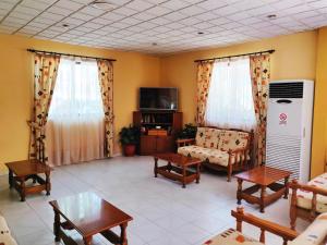 a living room filled with furniture and a tv at Titania Hotel Karpathos in Karpathos