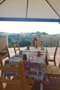a dining room table with chairs and a view of the countryside at Il Gelso Country House in Castorano
