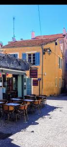 un restaurant avec des tables et des chaises en face d'un bâtiment dans l'établissement Maison de ville en plein cœur de Sanary 3 double chambres 105M2, à Sanary-sur-Mer