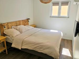 - une chambre avec un grand lit et une tête de lit en bois dans l'établissement Maison de ville en plein cœur de Sanary 3 double chambres 105M2, à Sanary-sur-Mer