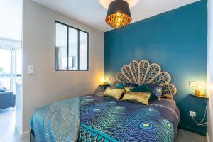 a bedroom with a bed with a blue wall at Zen et Summer Zen coursive naturiste in Cap d'Agde
