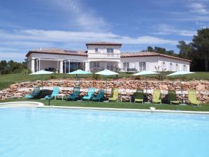 a house with a swimming pool with chairs and umbrellas at Villa 342 m2 classée 4 étoiles sur 1 ha - Provence in Besse-sur-Issole