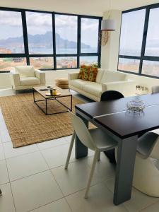 a living room with a couch and a table and chairs at Kasa Imbondeiro in Mindelo