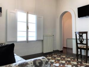 een woonkamer met een raam en een stoel bij THE BLUE LODGE-cozy flat close to Piazza del Campo in Siena