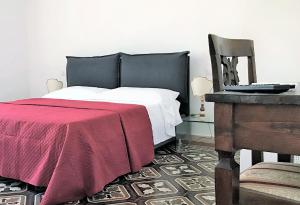 a bedroom with a bed with a red blanket and a chair at THE BLUE LODGE-cozy flat close to Piazza del Campo in Siena