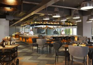 a restaurant with tables and people in the kitchen at Brittany Hotel BGC in Manila