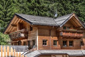 a log cabin with two decks and a fence at Bar Garni Reischnhitt des Eschgfeller Christoph in Sarntal