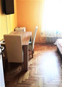 ハイドゥソボスローにあるAlex's Apartman & Panzióのダイニングルーム(木製テーブル、椅子付)