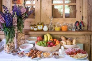 a table with bowls of fruits and vegetables on it at Bar Garni Reischnhitt des Eschgfeller Christoph in Sarntal +9 photos