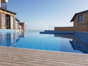 a pool with blue water next to a building at Apartman Pahulja - Milmari in Kopaonik