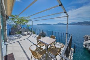 a table and chairs on a balcony overlooking the water at Kazanegra Exclusive Apartments in Sveti Stefan