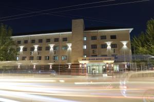 un edificio di notte con una strada davanti di Osh Grand Hotel Chavo a Oš