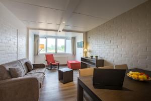ein Wohnzimmer mit einem Sofa und einem Tisch in der Unterkunft Vakantie Domein Ter Helme in Oostduinkerke
