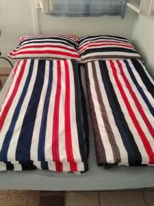 two striped pillows on a bed in a room at Jómadarak Nyaralója in Veresegyház