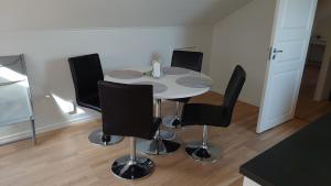 una mesa blanca con sillas negras en una habitación en Simones Hotel, en Vadstena