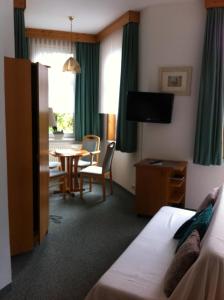a hotel room with a bed and a dining room at Pension Tannenrausch in Friedrichroda