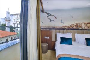 a hotel room with two beds and a window with birds at The Tango Hotel Taksim in Istanbul