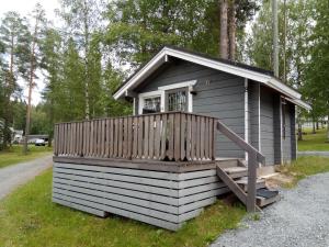 a small cabin with a porch and a deck at Revontuli Resort Cottages in Hankasalmi