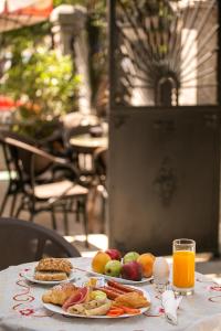 a table topped with plates of food and orange juice at Eagles Philadelfia in Korçë