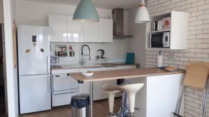 uma cozinha com electrodomésticos brancos e uma bancada de madeira em Appartement dernier étage Hyper Centre em Granville