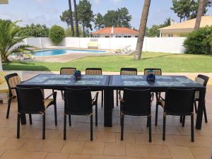 ein schwarzer Tisch mit Stühlen und ein Pool in der Unterkunft Villa near Beach & Lisbon in Corroios