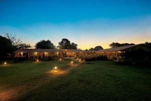 un bâtiment avec des lumières dans un champ la nuit dans l'établissement Asiatic Lion Lodge, à Sasan Gir