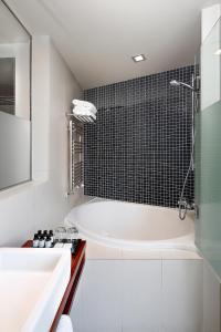uma casa de banho branca com uma banheira e um lavatório em Wilson Boutique Hotel em Barcelona