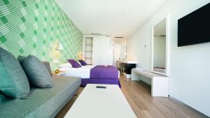 英格兰海滩Hotel Nayra - Adults Only的配有床和沙发的酒店房间