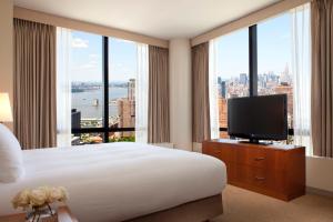 a hotel room with a large bed and a television at Millennium Downtown New York in New York