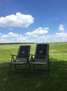 due sedie sedute nell'erba in un campo di De Kouterhoeve a Moorslede