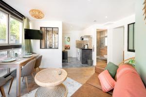 a living room with a couch and a table at Suites Gaya Confort - Centre Ville in Montpellier