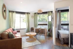 - un salon avec un canapé et une table dans l'établissement Suites Gaya Confort - Centre Ville, à Montpellier