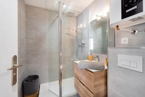 La salle de bains est pourvue d'une douche et d'un lavabo. dans l'établissement Suites Gaya Confort - Centre Ville, à Montpellier