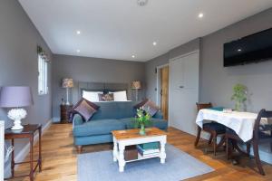 a living room with a blue couch and a table at The Old Engineer A rural boutique retreat in Yalding