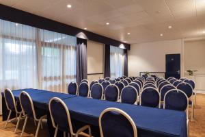 a conference room with a blue table and chairs at Kyriad Direct Rennes Ouest in Vezin-le-Coquet