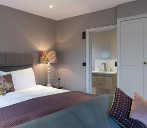a bedroom with a bed and a bathroom with a sink at The Old Engineer A rural boutique retreat in Yalding