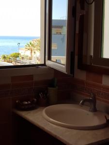a bathroom sink with a window and a view of the ocean at The Magic Dragonfly! in Santa Cruz de Tenerife